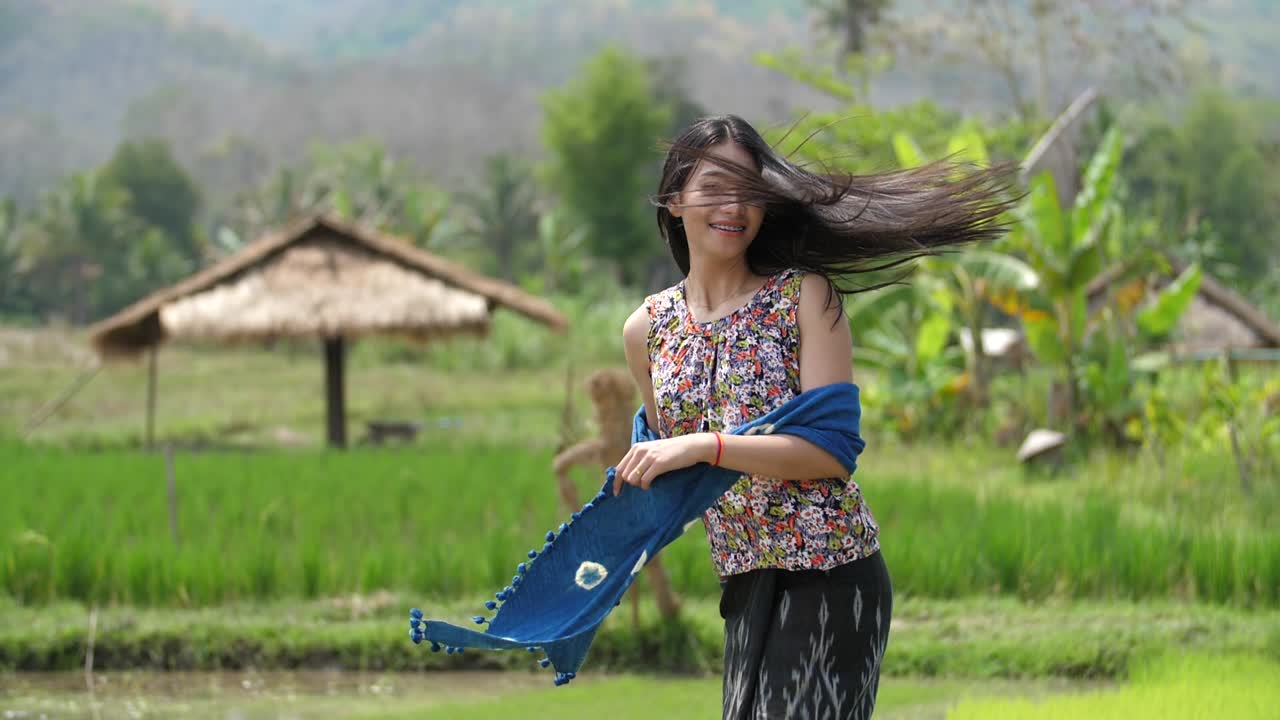 Smiling Asian Woman in Traditional Thai Clothing in a Rice Paddy