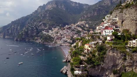 positano in the italian amalfi coast seen from the side showing colorful hillside mansions, aerial left pan reveal shot