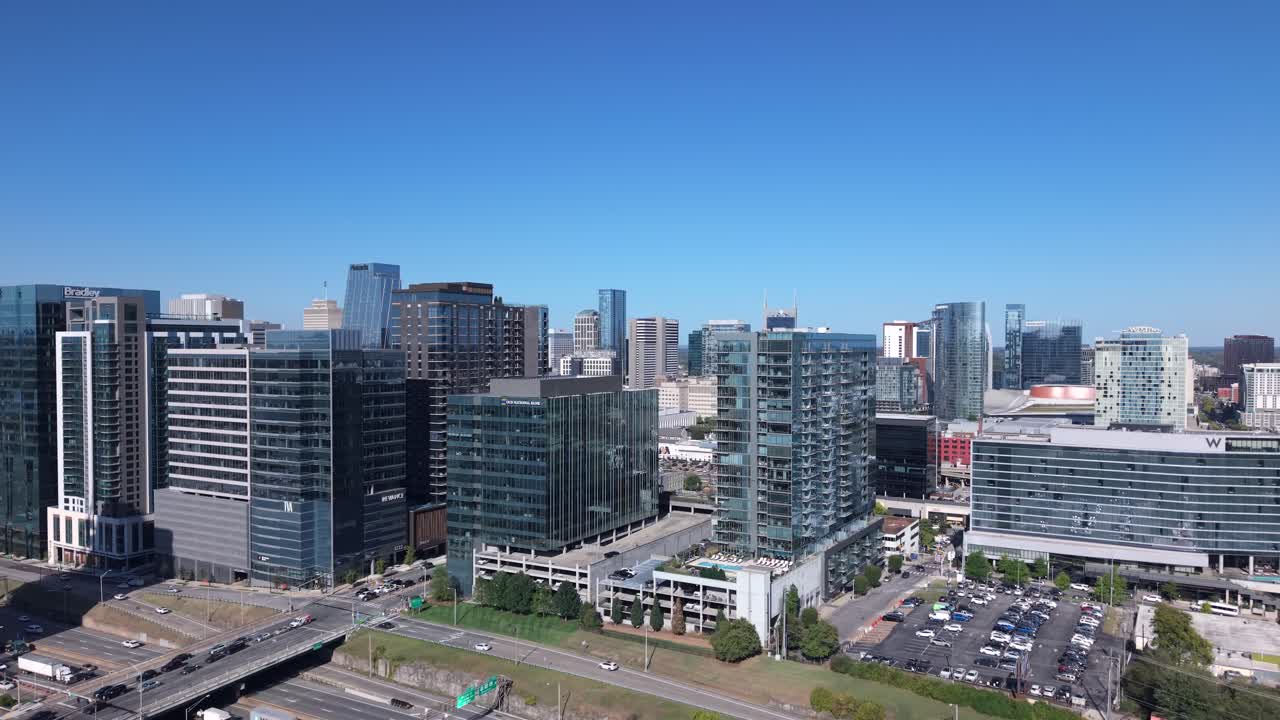 The modern skyline and bustling streets of The Gulch, Nashville, Tennessee in daytime ascending aerial reveal