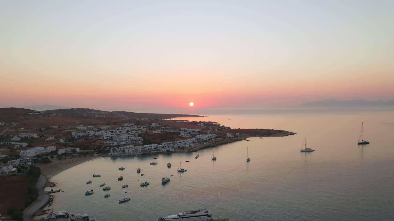 Sunrise colors reflect on still harbor water of Koufonisia Chora, Cyclades, Greece