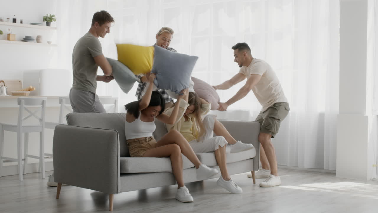 친구들이 베개 싸움을 하고 있습니다.