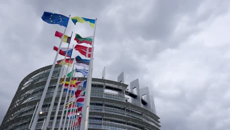 Ukrainian-flag-along-European-member-states-flags-in-front-of-the-EU-Parliament-in-Strasbourg,-France---Cinematic-zoom-in