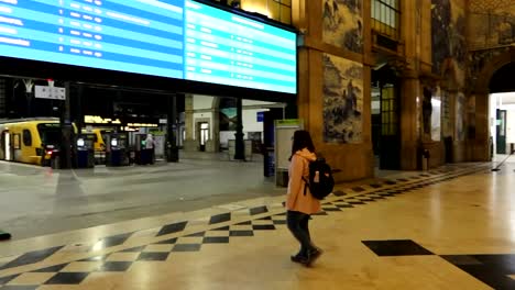 Mujer-Lista-Para-Tomar-Un-Tren-En-La-Estación-De-Tren-De-Sao-Bento,-Mural-De-Azulejos-Azules