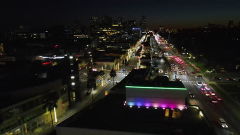 drone shot over the colorful, night lit cityscape of beverly hills, los angeles
