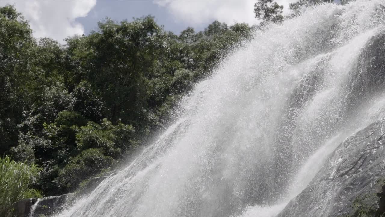 panorámica hacia abajo sobre aguas en cascada rápidas en cámara lenta desde la parte superior del terreno de roca de cascada