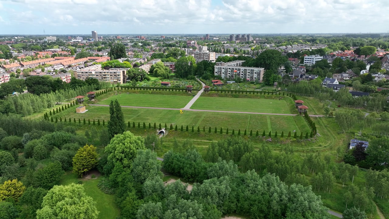 Aerial semi orbit over Matilo park, capturing tree-lined square fields and nearby residential architecture.