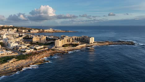 aerial view of l-jerma bay and abandoned jerma palace hotel in marsaskala, sunrise time, malta