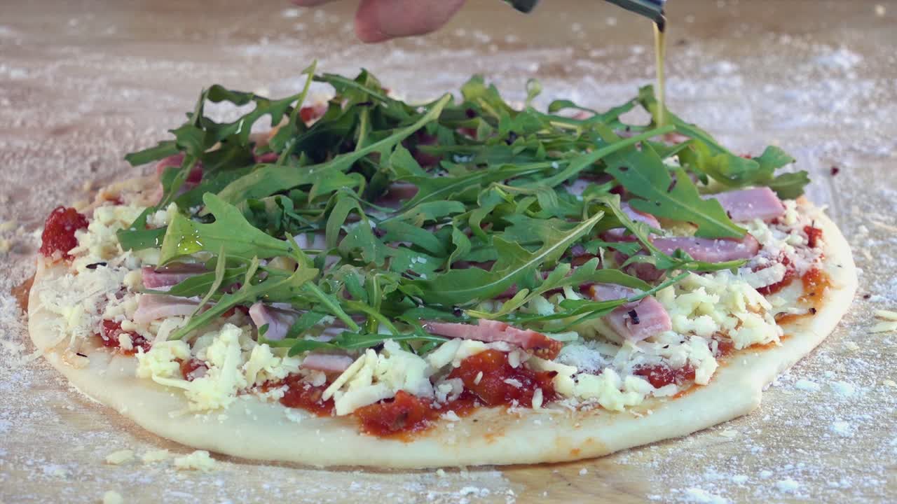 피자 위에 스트라 버진 올리브 오일을 뿌리는 것