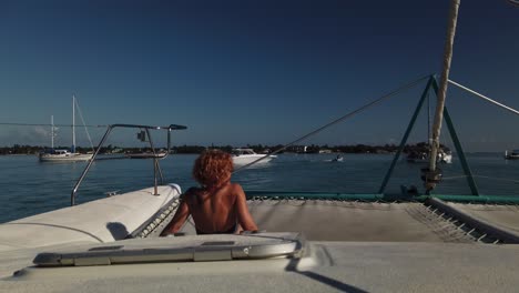 a shot of a woman enjoying the sun in a catamaran´s bow