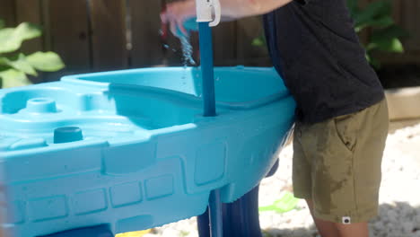 a kid splashing a toy boat in the water