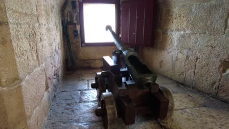 ancient cannon inside belem tower facing on embrasure in the fort wall in lisbon, portugal