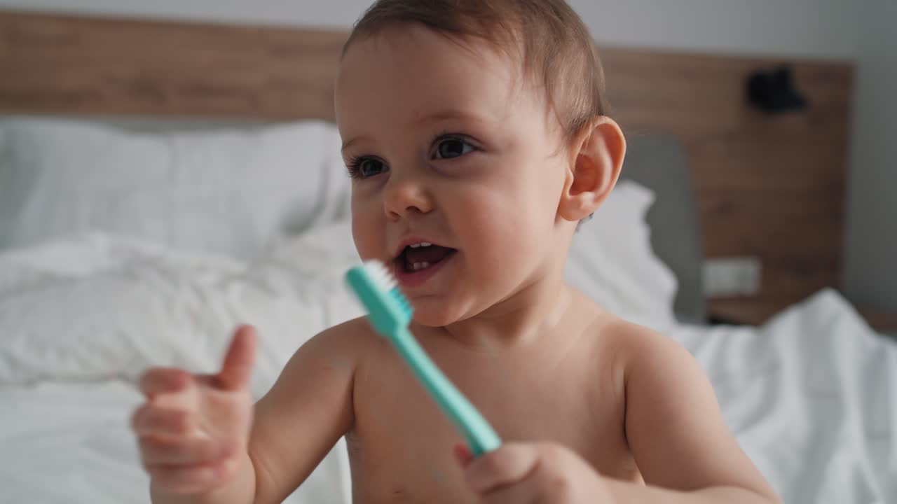 Video of cute caucasian baby brushing a teeth at home.