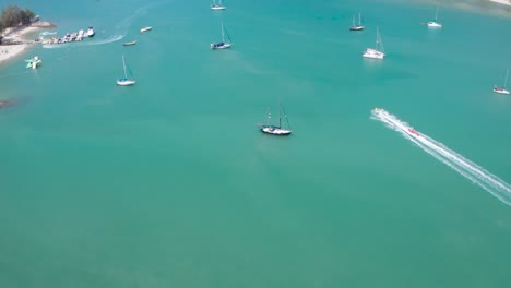 Aerial-footage-of-Banana-boat-full-of-people-having-fun-and-cruising-in-high-speed-attached-on-powerboat,-watersport