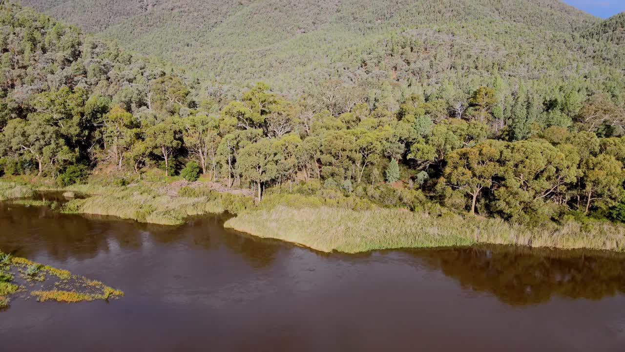 tomada de drone de la inclinación del río nevado inferior y la cordillera en el parque nacional de kosciuszko en un día de verano, nsw, australia
