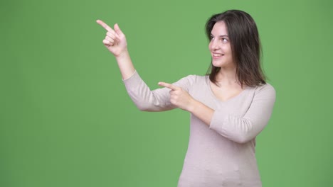young happy beautiful woman showing something while pointing finger up