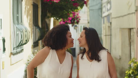 Front-view-of-female-couple-holding-hands-and-walking-outdoors-after-wedding-ceremony