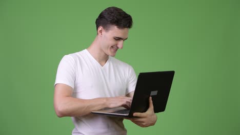 joven apuesto usando una computadora portátil