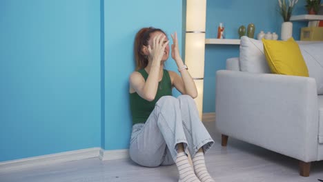 the woman sitting by the wall is angry with herself.