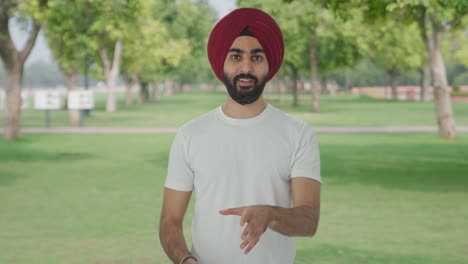 hombre indio sikh feliz hablando en el parque