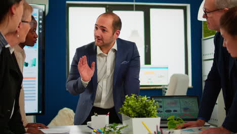 equipo de diversas empresas de nueva creación, colegas y empresarios discutiendo en una sala amplia