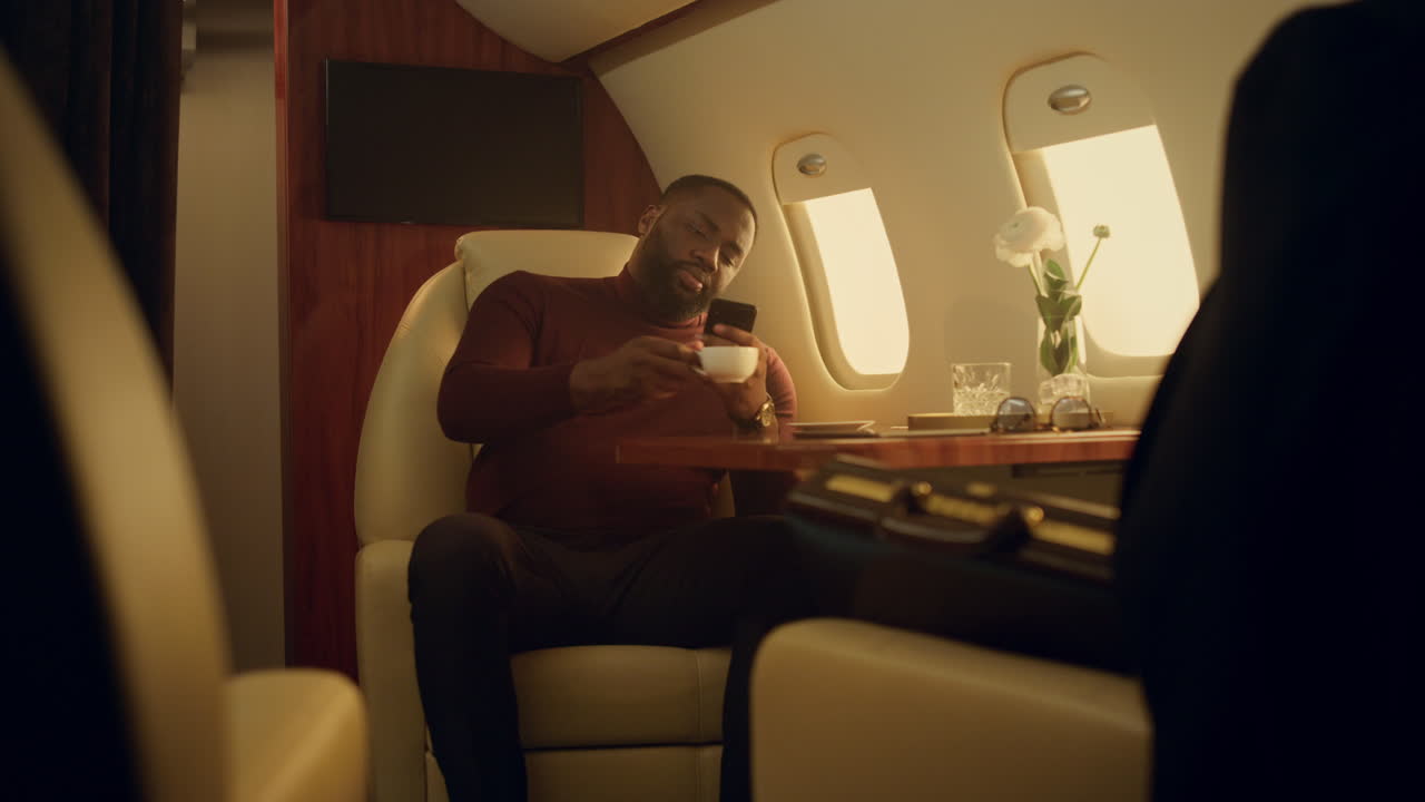 hombre feliz navegando por internet en primera clase. pasajero alegre bebiendo café