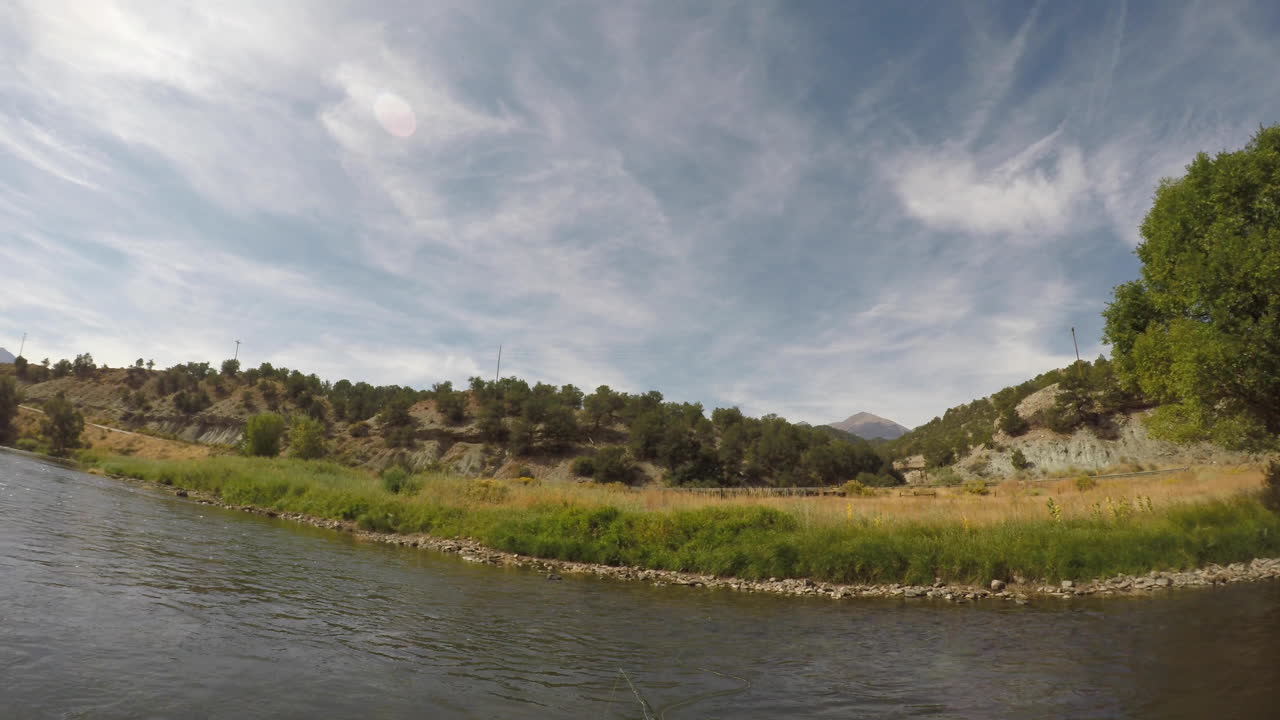 casting a fly rod on a river in the mountains