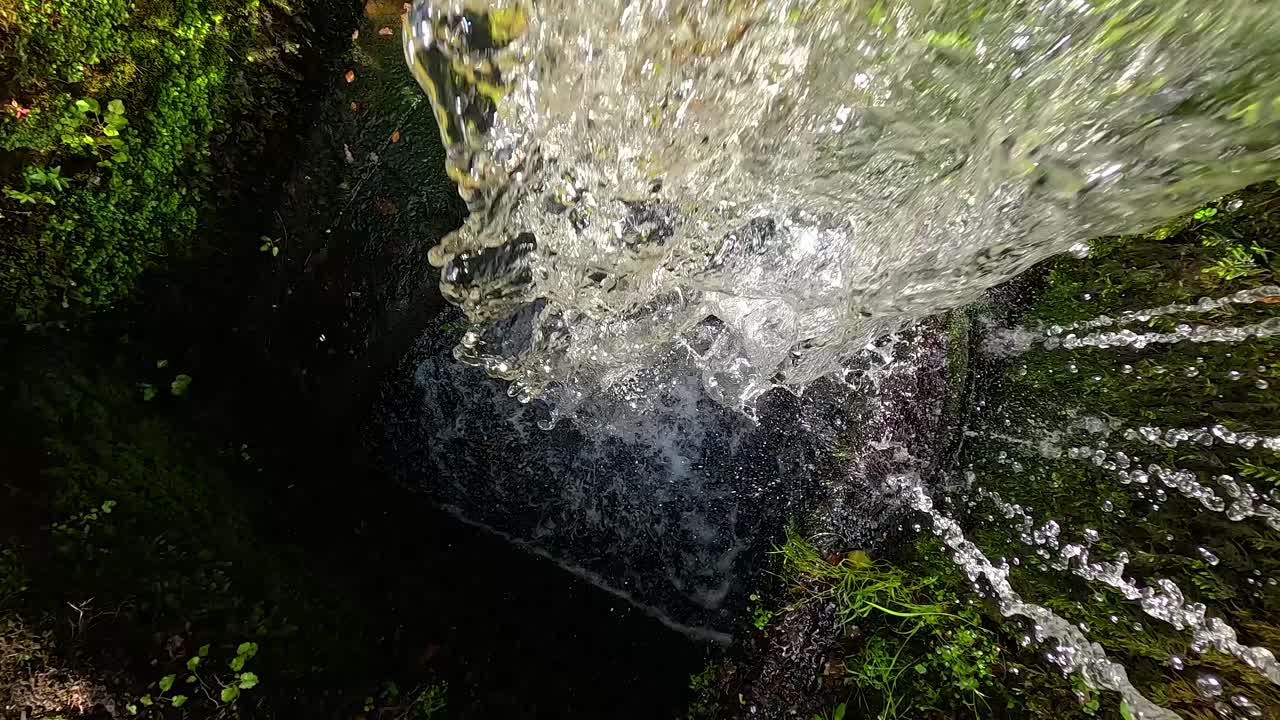 Cascata che scorre su rocce muschiose