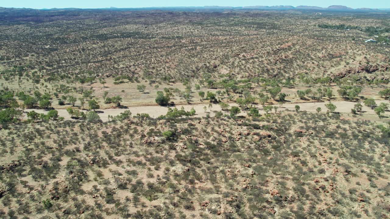 Sideways aerial view along the dry Todd River, north of Alice Springs, Mparntwe, Northern Territory, Australia. August 2022.