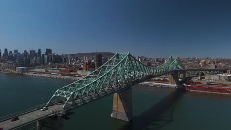 aerial-of-traffic-car-driving-along-The-Jacques-Cartier-Bridge-crossing-the-Saint-Lawrence-River-Montreal-Island,-Quebec