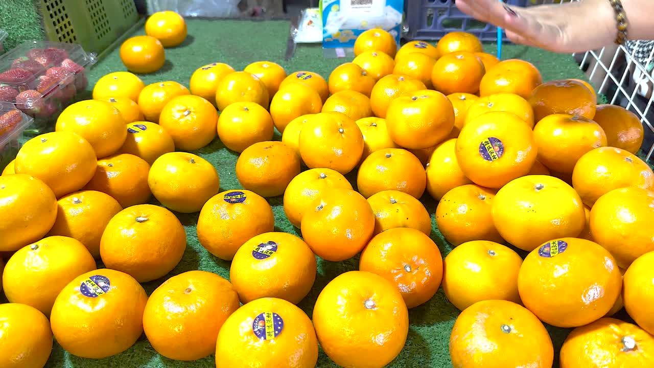 Woman selecting oranges at a market