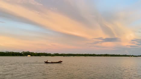 pescadores en un bote de madera en el río padma durante la puesta de sol