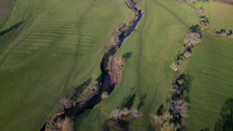 The-twisting-river-Arrow-running-through-the-winter-countryside-of-Warwickshire,-England