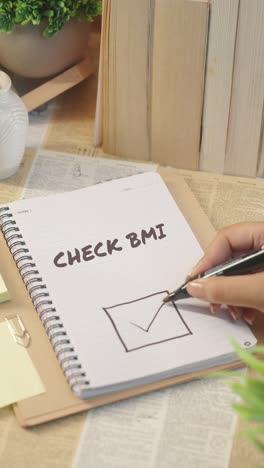 vertical video of ticking off check bmi from checklist