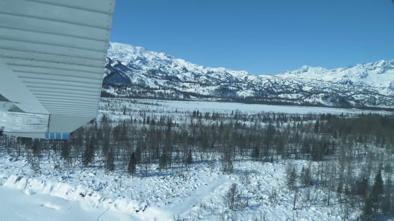 vuelo sobre las aguas heladas de la entrada de cook en alaska durante el invierno con vastas extensiones de bosques cubiertos de nieve, ríos, valles y picos de las montañas de la cordillera chugach