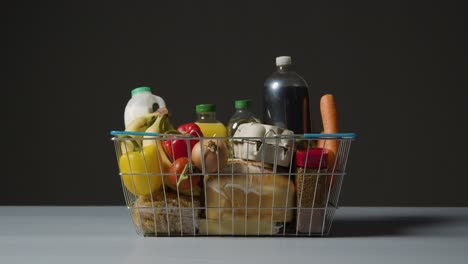 foto de estudio de alimentos básicos en la cesta de la compra de alambre de supermercado 2