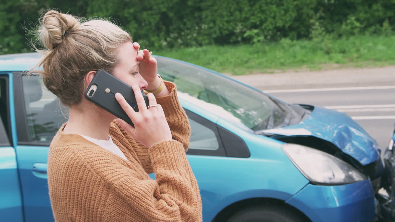자동차 사고 를 당한 여성 자동차 운전자 가 보험 회사 나 복구 서비스 에 전화 하는 것