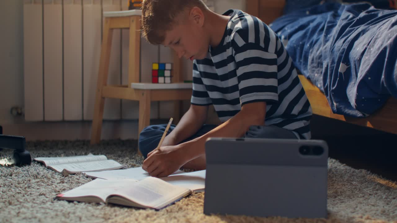 Child doing homework on the floor in a bedroom