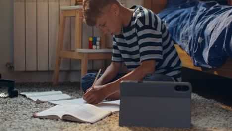 child doing homework on the floor in a bedroom