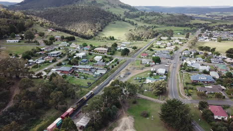 drone se levanta siguiendo el tren que pasa por la ciudad rural en tasmania, australia