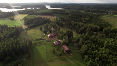 aerial view of farm houses in a beautiful sunset atmosphere on the countryside, finland, kuopio, vehmersalmi, stunning forest and lake landscape