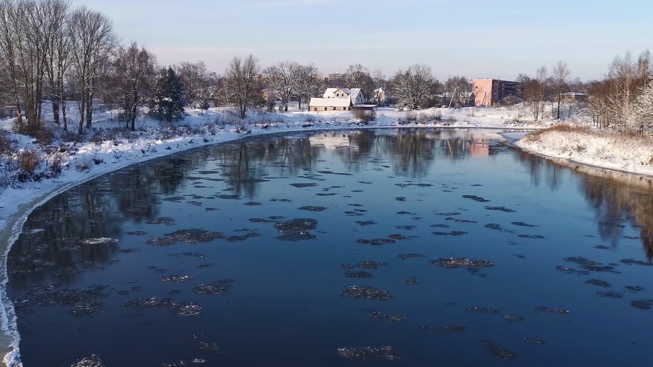Wide shot of ice floating in a river on a sunny winter day