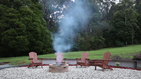 un bucle sin fisuras de humo que se eleva suavemente desde un pozo de fuego en un acogedor patio trasero