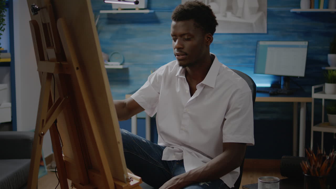 Artista di colore che usa una matita e un'area di disegno bianca su un cavalletto per il design