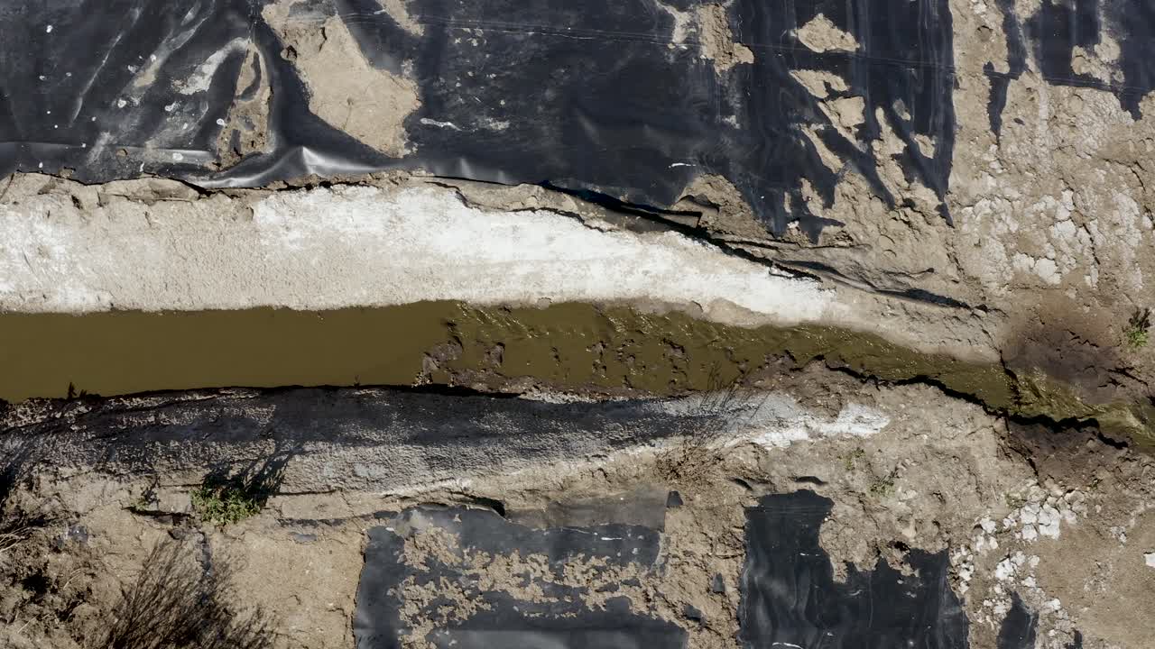 toma aérea de una laguna de estiércol sobre un pico de flujo que drena hacia la siguiente celda