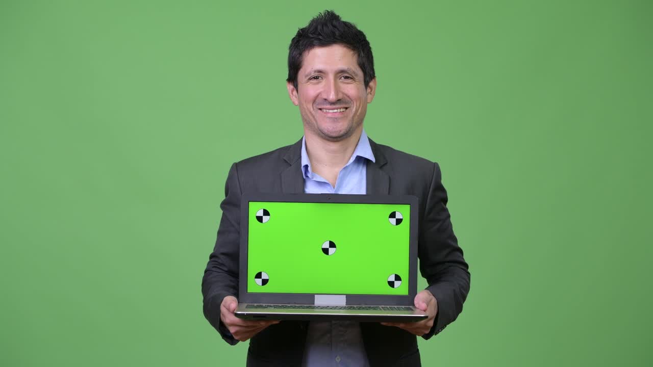 Happy Hispanic businessman showing laptop