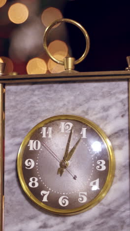 golden clock showing one hour. beautiful old clock on blurred christmas background. close-up. vertical video
