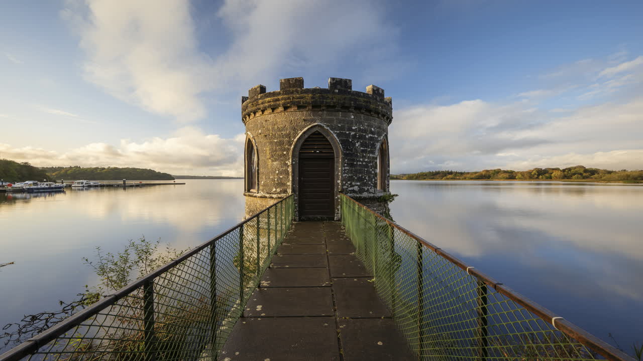 lapso de tiempo de una torre medieval en el lago con cielo dramático en irlanda rural