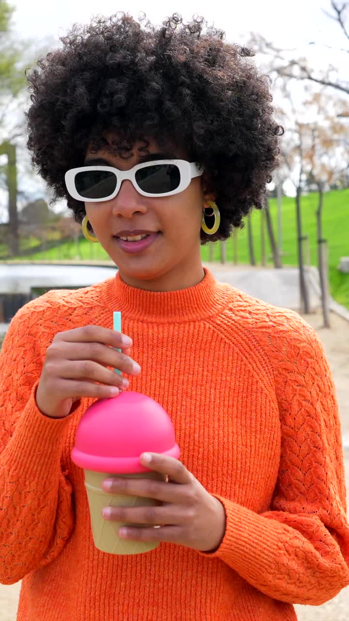 Woman with Curly Hair Drinking from Ice Cream Cup