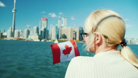 woman with canadian flag looks at toronto