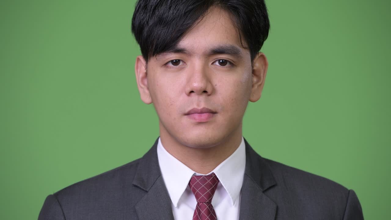 젊은 잘생긴 아시아 사업가 머리를 흔들고